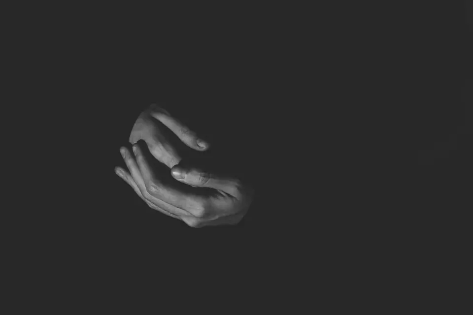 Black and white study of a pair of hands against a dark background