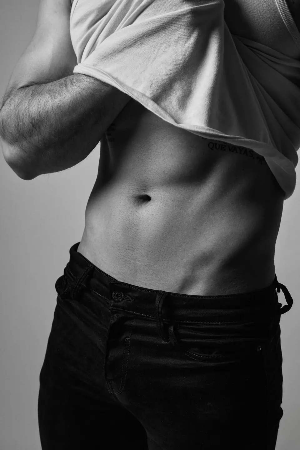 Black and white study of a torso in low studio light